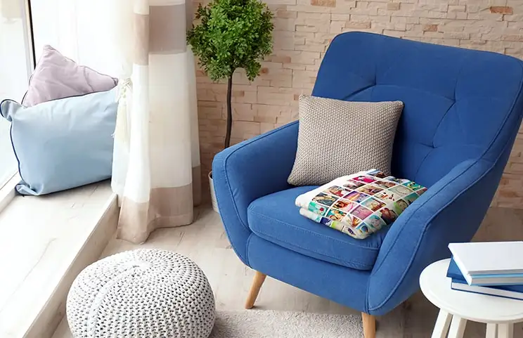 Een knusse blauwe fauteuil met een gepersonaliseerde fotodeken, perfect voor gezellige momenten thuis.