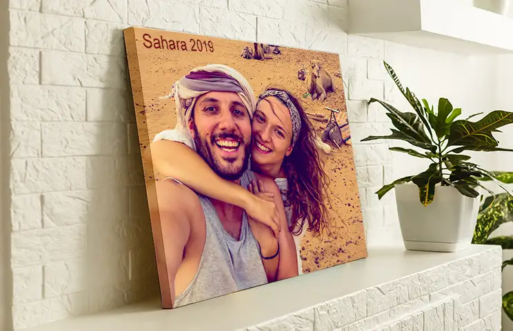 Gepersonaliseerd canvas: een koppel omhelst elkaar voor een kameel in de Sahara (2019).