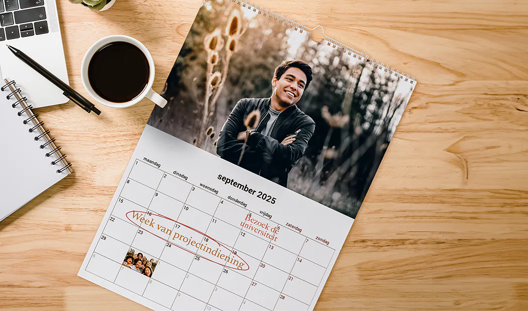 Gepersonaliseerde september 2025 kalender met foto, op houten bureau naast koffie en notitieboek.