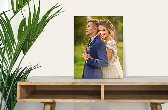 Gepersonaliseerd bruidspaarportret op canvas: romantische foto van een gelukkig paar, buiten geschoten, op een houten kast.